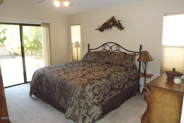 carpeted bedroom with vaulted ceiling and access to outside