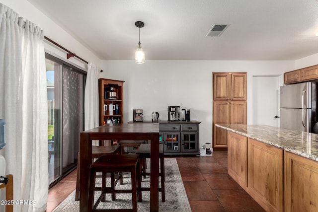 dining room featuring dark tile patterned floors and visible vents