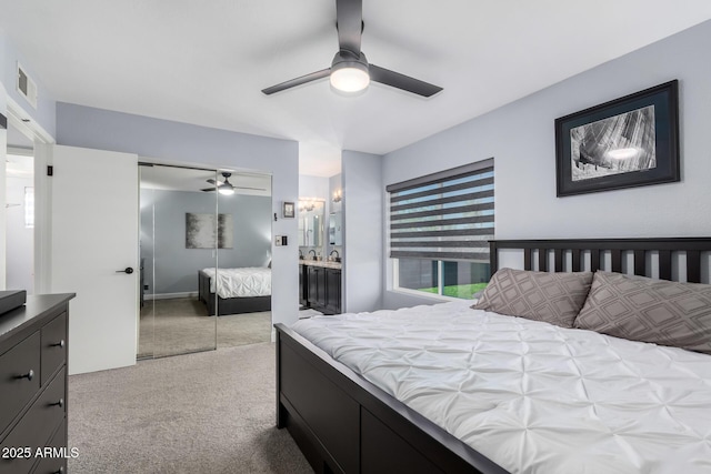 bedroom with ceiling fan, visible vents, a closet, and light colored carpet