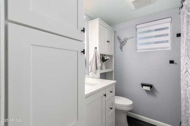 bathroom with toilet, baseboards, visible vents, and vanity