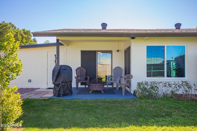 rear view of house featuring a patio area, an outdoor fire pit, and a lawn