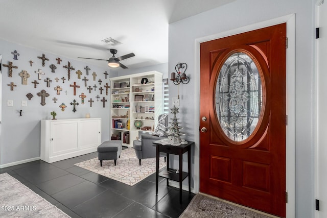 foyer entrance featuring baseboards, dark tile patterned flooring, visible vents, and a ceiling fan