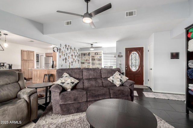 living room with visible vents, ceiling fan, and baseboards