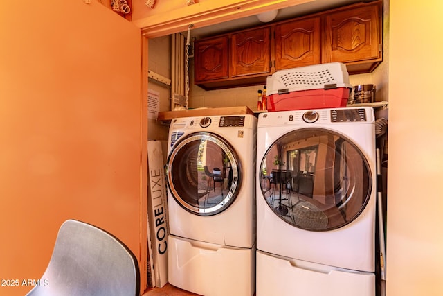 clothes washing area featuring cabinet space and independent washer and dryer