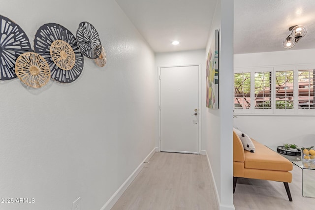 doorway with baseboards and wood finished floors