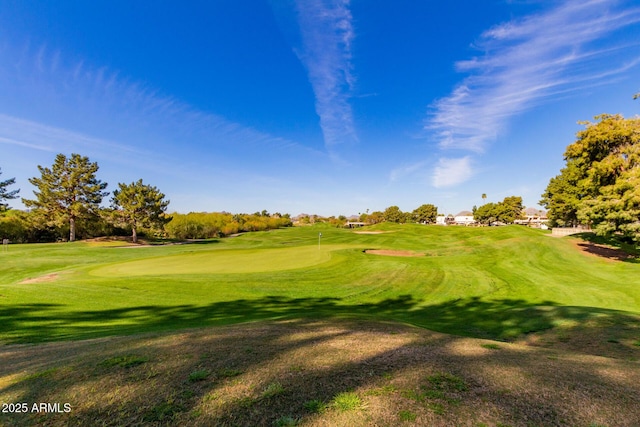 surrounding community with view of golf course and a yard