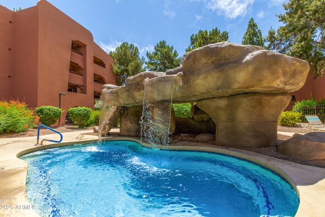 outdoor pool featuring fence