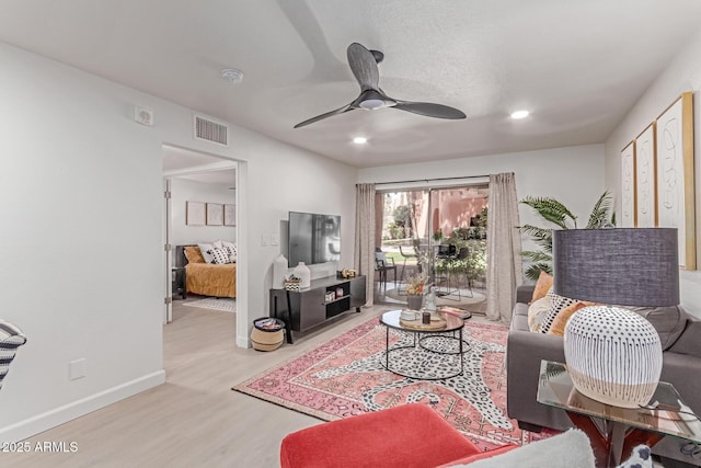 living area with a ceiling fan, baseboards, recessed lighting, wood finished floors, and visible vents