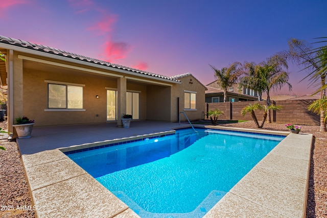 pool at dusk featuring a patio area