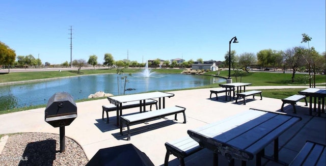 view of home's community with a lawn and a water view