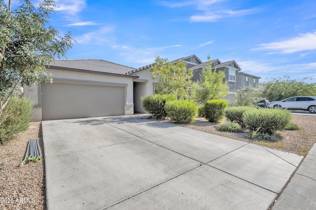 6085 E Athena Rd, Florence, AZ 85132 - view of front facade with driveway, a tiled roof, a garage, and stucco siding
