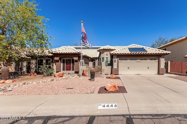 view of front facade featuring an attached garage, fence, a tiled roof, concrete driveway, and stucco siding