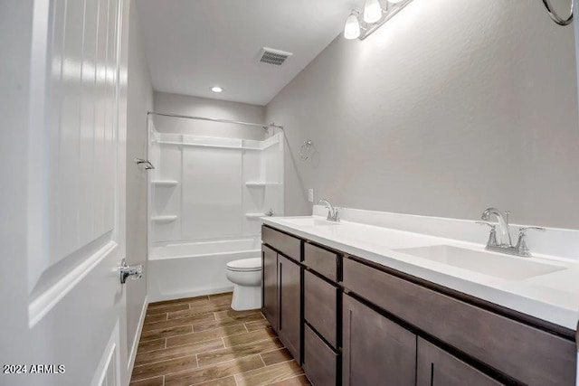 full bathroom featuring hardwood / wood-style floors, vanity, toilet, and bathing tub / shower combination