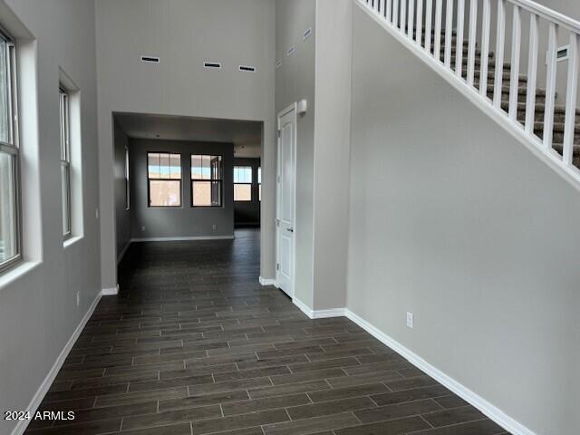 hall with dark hardwood / wood-style floors and a high ceiling