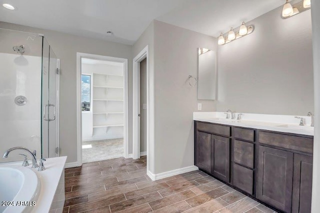 bathroom featuring shower with separate bathtub and vanity