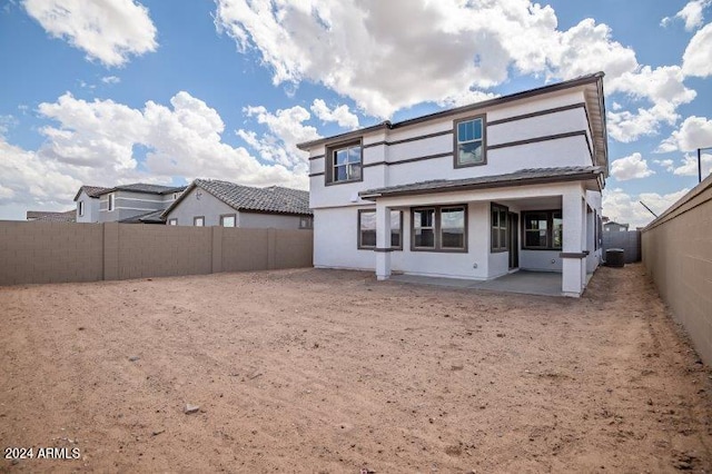 back of property with central AC unit and a patio area