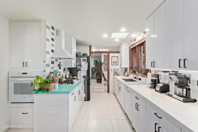 301 W Royal Palm Rd, Phoenix, AZ 85021 - kitchen with white oven, wall chimney exhaust hood, a sink, light countertops, and recessed lighting