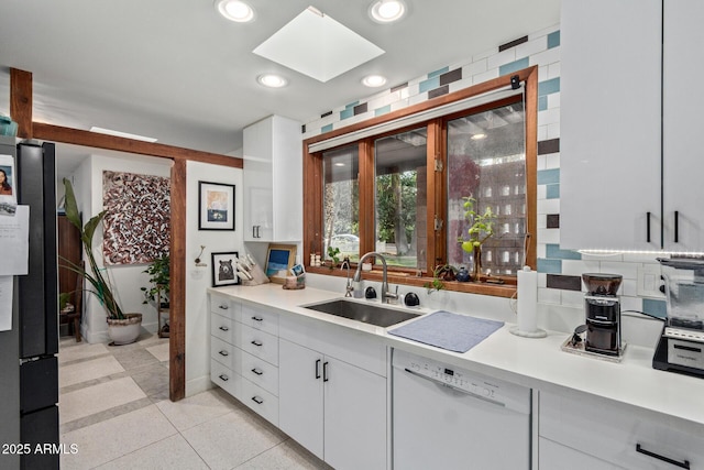 301 W Royal Palm Rd, Phoenix, AZ 85021 - kitchen featuring white dishwasher, a sink, a skylight, light countertops, and white cabinetry