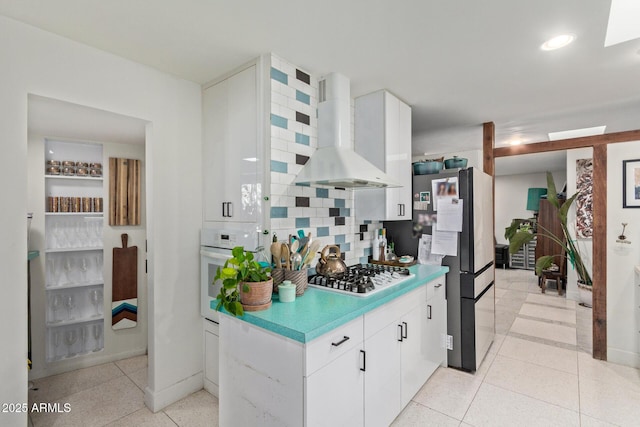 301 W Royal Palm Rd, Phoenix, AZ 85021 - kitchen with wall chimney range hood, oven, gas cooktop, freestanding refrigerator, and backsplash