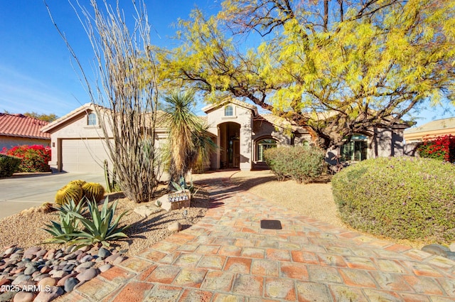 mediterranean / spanish house with an attached garage, stucco siding, and driveway