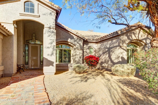 view of front of property with a patio area, stucco siding, and a tiled roof