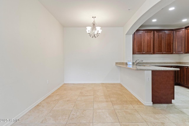 kitchen with a peninsula, baseboards, pendant lighting, and recessed lighting