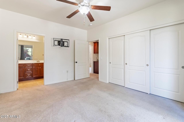 unfurnished bedroom with light carpet, connected bathroom, a ceiling fan, and a closet