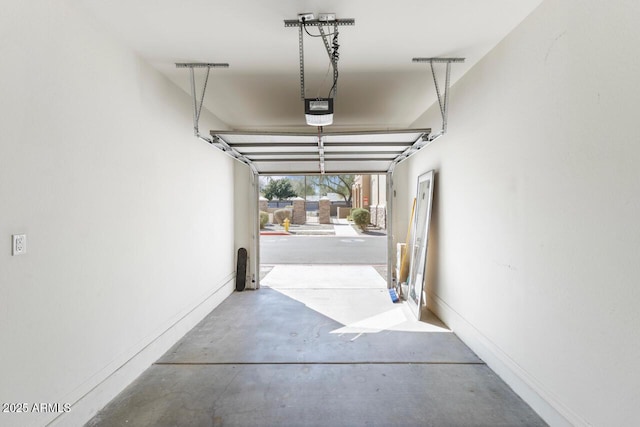 garage with baseboards and a garage door opener