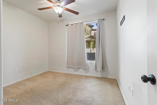 unfurnished room with baseboards, a ceiling fan, and light colored carpet