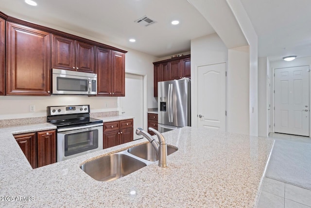 kitchen featuring visible vents, light stone countertops, stainless steel appliances, a sink, and recessed lighting