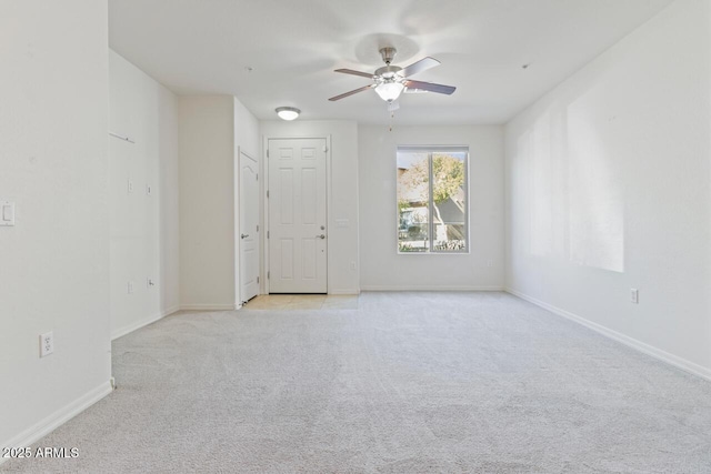 unfurnished room featuring light carpet, ceiling fan, and baseboards