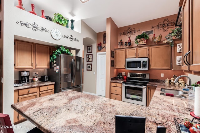 kitchen featuring a breakfast bar area, light stone countertops, sink, and stainless steel appliances