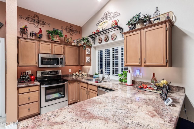 kitchen featuring kitchen peninsula, light stone countertops, stainless steel appliances, sink, and lofted ceiling