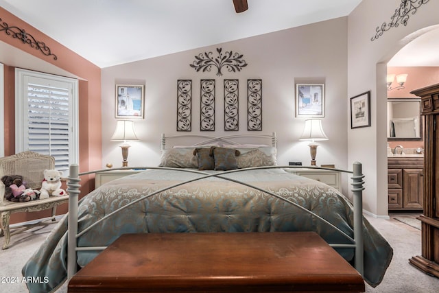 carpeted bedroom featuring ensuite bath, ceiling fan, and lofted ceiling