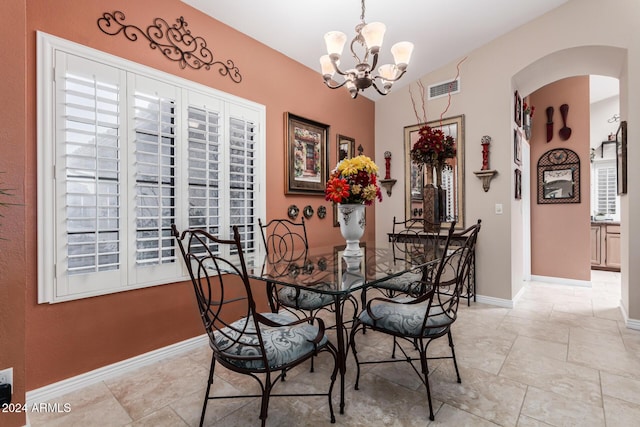 dining room featuring a notable chandelier and vaulted ceiling