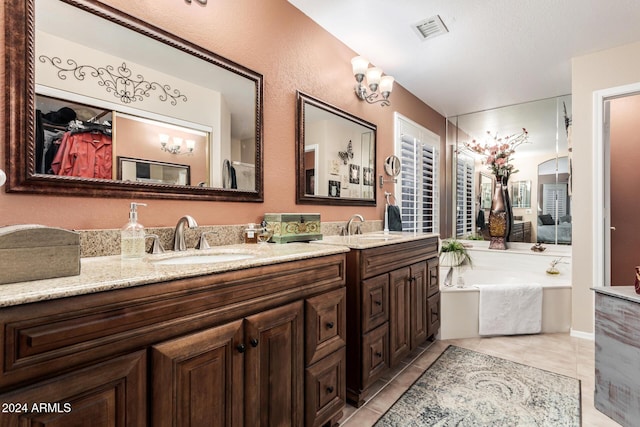 bathroom featuring tile patterned floors, vanity, a bath, and a notable chandelier