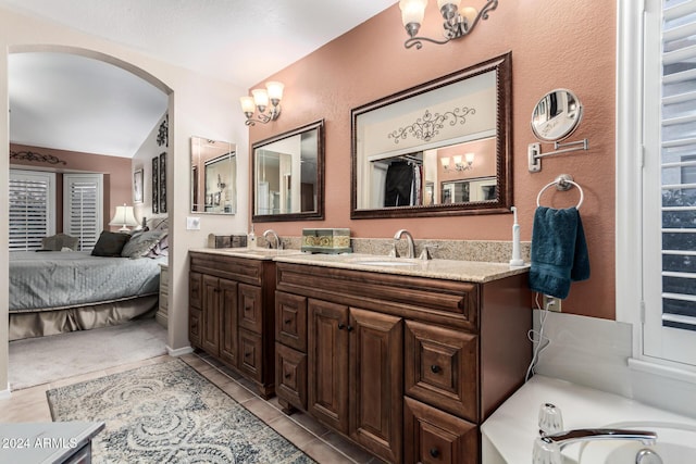 bathroom featuring tile patterned flooring, vanity, and vaulted ceiling