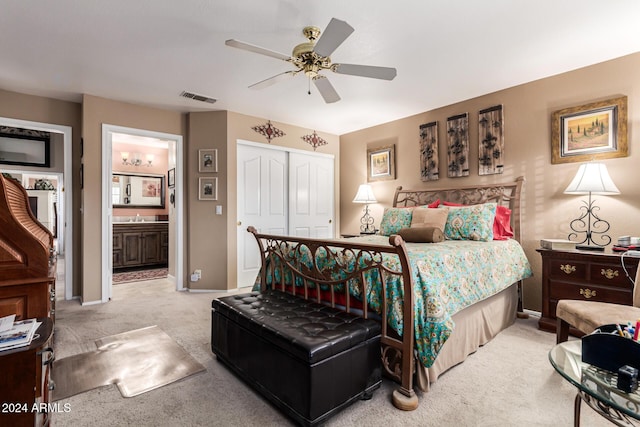 bedroom featuring ensuite bathroom, sink, ceiling fan, light colored carpet, and a closet