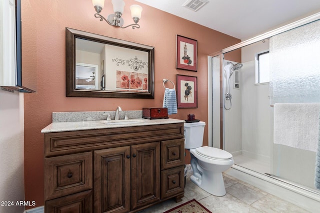 bathroom with tile patterned flooring, vanity, an enclosed shower, and a notable chandelier