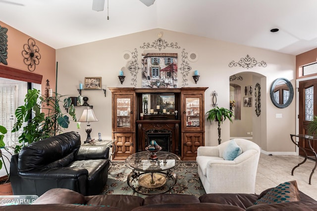 tiled living room featuring ceiling fan and lofted ceiling