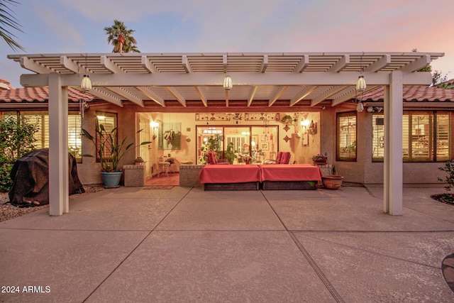 patio terrace at dusk featuring a pergola