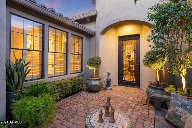 exterior entry at dusk featuring a patio area