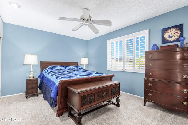 carpeted bedroom with a textured ceiling and ceiling fan