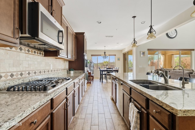 kitchen with hanging light fixtures, a sink, visible vents, and stainless steel appliances