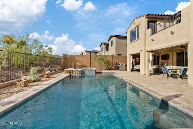 view of swimming pool featuring a patio area, a fenced backyard, a pool with connected hot tub, and a grill