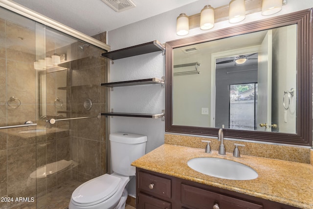 bathroom featuring a shower with shower door, toilet, and vanity with extensive cabinet space