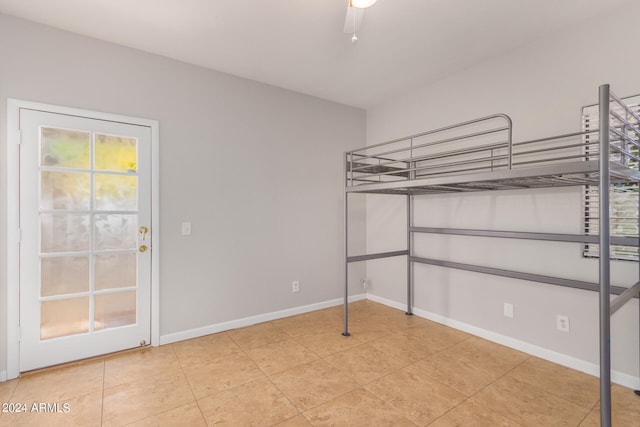 interior space with ceiling fan and light tile floors