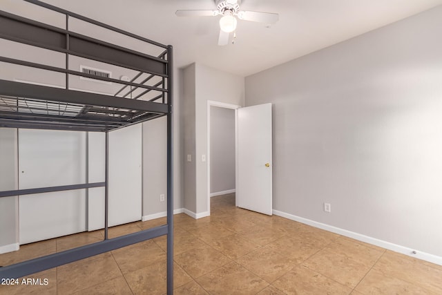 unfurnished bedroom featuring ceiling fan and light tile floors