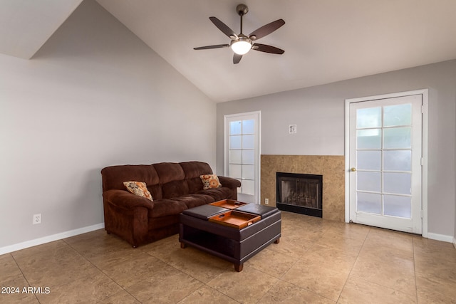 tiled living room featuring vaulted ceiling, a tiled fireplace, and ceiling fan