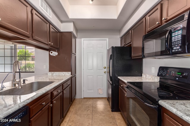 kitchen featuring black appliances, dark brown cabinets, sink, light tile floors, and a raised ceiling